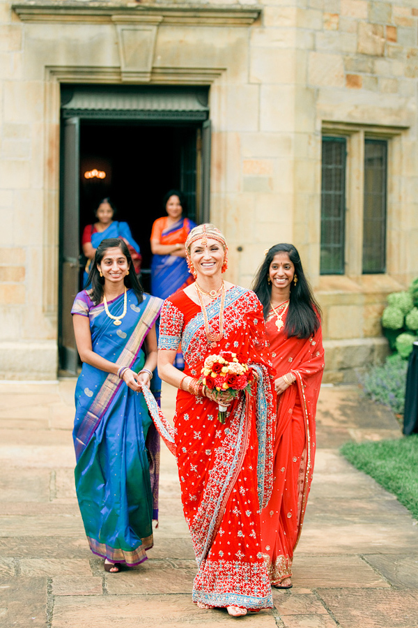 beautiful bride, in red sari, walking down the aisle - photo by Chicago based wedding photographers Harrison Studio